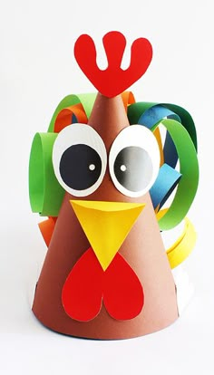 a paper turkey with large eyes and horns on it's head, sitting in front of a white background