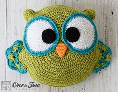 a crocheted owl hat with big eyes on a white wooden background, close up