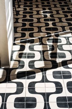 the shadow of a person standing on a tiled floor