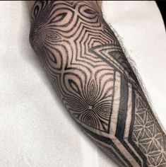 a man's arm with black and white geometric designs on the side of his leg