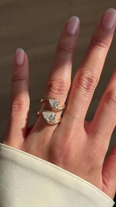 a woman's hand with two rings on it