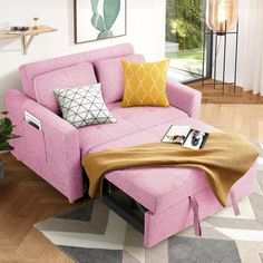 a living room with a pink couch and ottoman