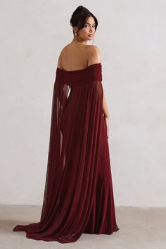 a woman in a long red dress is looking off to the side