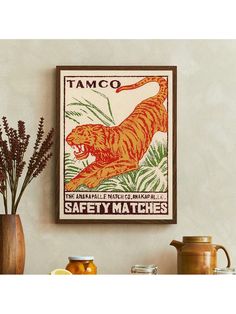 a tiger poster hangs on the wall above some jars and vases with flowers in them