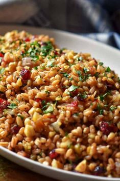 a white plate topped with brown rice and cranberry sauce on top of a wooden table