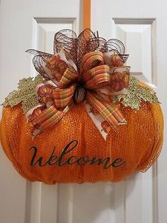 a welcome pumpkin hanging on the front door