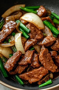 beef, onions and asparagus stir fry in a wok