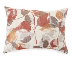 an orange and white pillow with red leaves on the front, sitting on a white surface