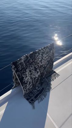 the back end of a boat with a black and white blanket hanging from it's side