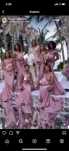 a group of women in pink dresses standing next to each other with flowers on them