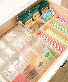 an organized drawer with teas, coffee bags, and other items in the drawers