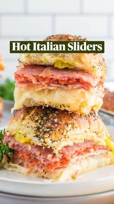 two ham and cheese sandwiches stacked on top of each other with parsley sprigs