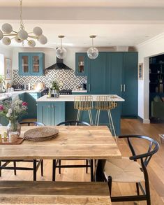 a kitchen with blue cabinets and wooden tables