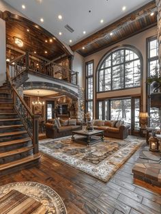 a large living room with wooden floors and high ceilings, windows on the wall, stairs to the second floor