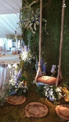 an outdoor area with swings, flowers and greenery