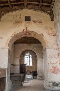 an old church with painted walls and pews in the aisle leading up to it