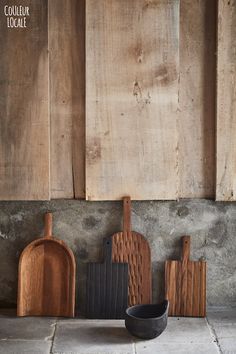 wooden cutting boards and spatulas are lined up against the wall