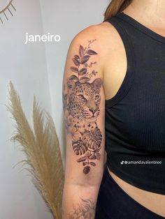 a woman with a tattoo on her arm is standing in front of a plant and an animal