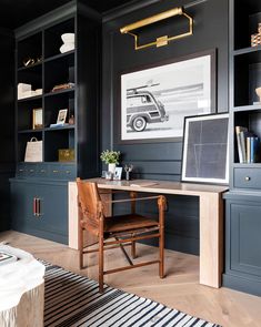 a home office with black walls and wooden furniture