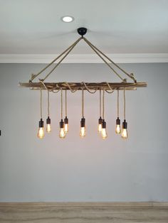 a chandelier with five lights hanging from it's sides in an empty room