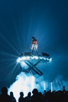 a man standing on top of a metal object in front of a group of people