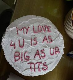 a cake with writing on it sitting on a table next to a bowl of fruit