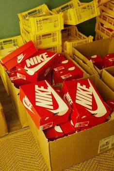 many boxes of nike brand shoes are stacked on top of each other in a room