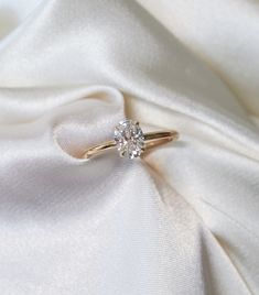 a diamond ring sitting on top of a white cloth