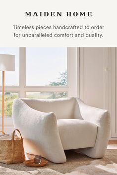 a white chair sitting in front of a window next to a lamp and basket on the floor