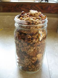 a glass jar filled with granola sitting on top of a counter