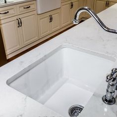 a white sink sitting under a kitchen faucet