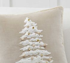 a white christmas tree pillow sitting on top of a couch