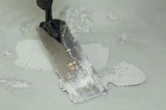 a close up of a snowplow on the ground with white powder around it