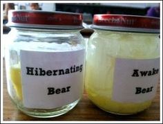 two jars filled with yellow liquid sitting on top of a table