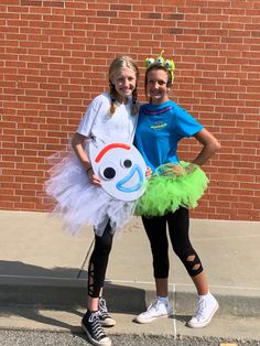 two girls dressed up in costumes standing next to each other