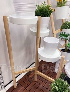 several white pots and planters on display in a room with red brick flooring