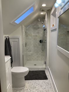 a bathroom with a white toilet sitting next to a walk in shower