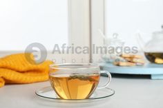 a cup of tea sitting on top of a saucer next to a yellow towel