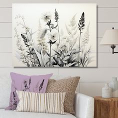 a living room with white furniture and flowers on the wall