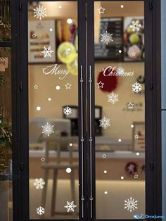 an open glass door with snowflakes on it and the words merry christmas written in white