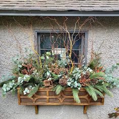 a window box filled with plants and greenery