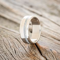 the wedding band is made out of wood and has silver inlays on it