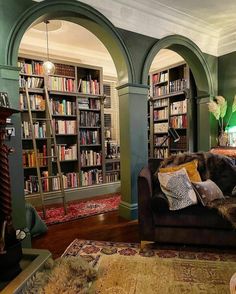 a living room filled with lots of furniture and bookshelves covered in bookcases