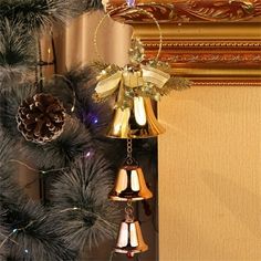 a bell hanging from the side of a christmas tree with pine cones and bells attached to it