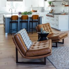 a living room filled with furniture and a kitchen in the backgroung area