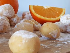 oranges and doughnuts on a cutting board next to some powdered sugar