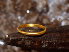 This is a solid gold ring constructed using pure 24k gold.  I start with refined .999 pure gold and melt it to red hot liquid metal, then forge it into a bar which is painstakingly rolled and hammered into the finished ring you see. The brilliance of pure 24k (99.9% gold content) gold is unmistakable. The rich color stands out from most standard jewelry that is made from 14k (58.3% gold content) and 18k (75% gold content) jewelry. The band is half-round, so it is flat on the inside and domed on Gold Specimens, Gold Nugget Ring, Natural Gold Nugget, Stacker Rings, Gold Nugget, Natural Gold, Round Rings, Solid Gold Rings, Gold Hands