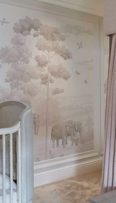 a baby crib in front of a wall with elephants on it