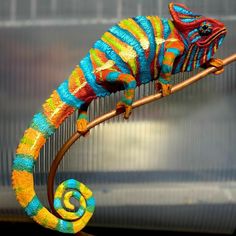 a colorful chamelon sitting on top of a wooden stick