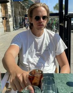 a man sitting at a table with drinks in front of him